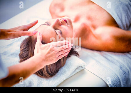 Les mains du thérapeute recadrée performing reiki à femme Banque D'Images