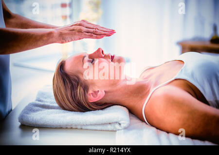 Les mains du thérapeute recadrée performing reiki à femme Banque D'Images