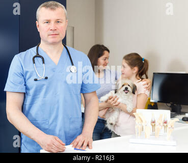 Portrait d'homme professionnel vétérinaire clinique vétérinaire moderne à poser avec les visiteurs derrière Banque D'Images