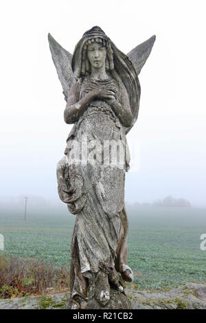 Lone statue d'un ange dans les champs Banque D'Images