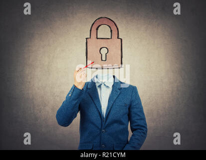 Image surréaliste comme un homme d'affaires avec invisible face à la tenue d'un crayon dans sa main attirer l'icône de verrouillage au lieu de tête. En tant que symbole de cadenas de sécurité dans l'entreprise Banque D'Images