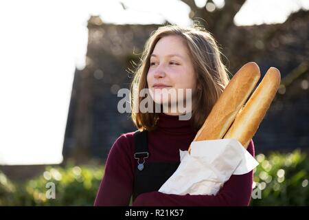 Jeune fille française avec la baguette sur le côté de la rue de la ville Banque D'Images