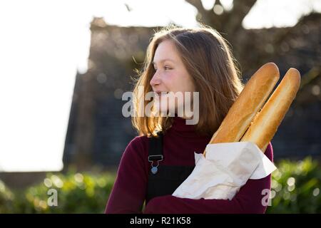 Jeune fille française avec la baguette sur le côté de la rue de la ville Banque D'Images