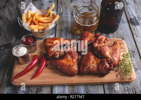 Ailes de poulet grillées, frites, sauce blanche et rouge. Snack-Bière Banque D'Images