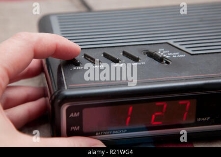 Poussant le bouton snooze ou dormir sur un vieux réveil analogique Banque D'Images