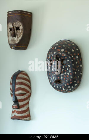 Avis de trois masques en bois décoratif, moulé et peint à la main, sur le mur de la maison... Banque D'Images