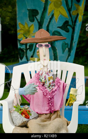 Femme portant des lunettes et un chapeau de l'épouvantail assis dans le jardin communautaire, Yarmouth MOI Banque D'Images