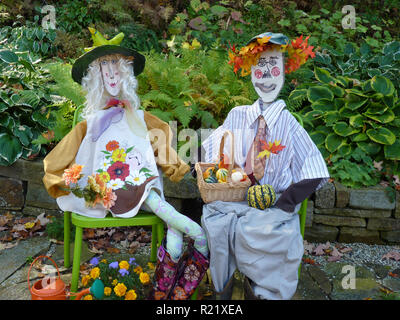 L'automne coloré épouvantails habillé pour le dîner assis ensemble célébration de la récolte, Yarmouth jardin communautaire, Maine, USA Banque D'Images