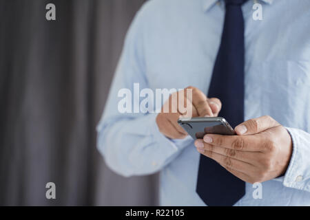L'homme d'affaires maintenez votre smartphone dans la rue et l'espace de copie. Banque D'Images