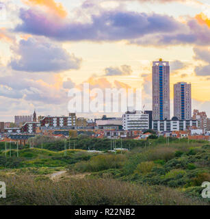 Situation touristique populaire et Scheveningen aux Pays-Bas une ville près de la plage au coucher du soleil vue depuis les dunes sur les édifices patrimoniaux et gratte-ciel Banque D'Images