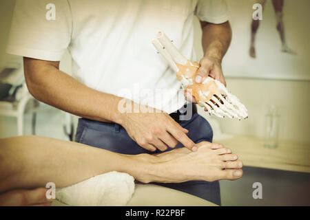 Physiothérapeute expliquant au patient modèle pieds Banque D'Images