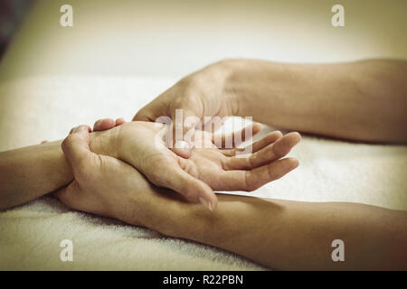 Physiothérapeute massage des mains donnant à une femme Banque D'Images