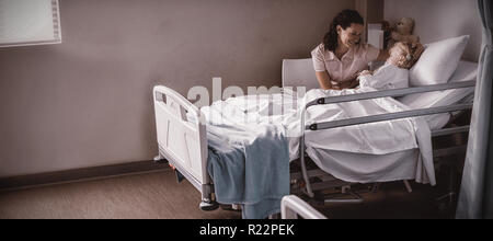 Femme médecin patient consolant pendant une visite dans la région de Ward Banque D'Images