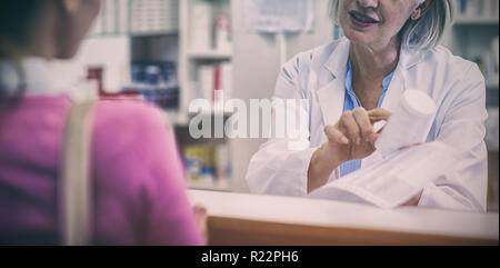 Pharmacien aider la bouteille de médicament au client Banque D'Images