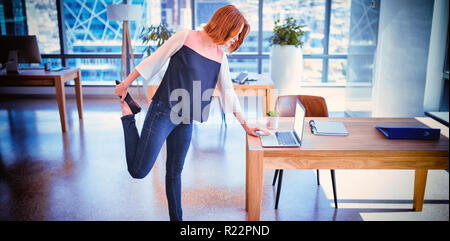 Exécutif attentif à l'aide d'ordinateur portable tout en exerçant Banque D'Images