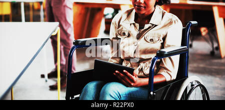 Mobilité business executive in wheelchair using digital tablet Banque D'Images