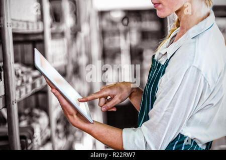 Le personnel féminin using digital tablet in supermarket Banque D'Images