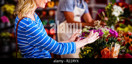 Woman taking photograph of bouquet de fleurs Banque D'Images