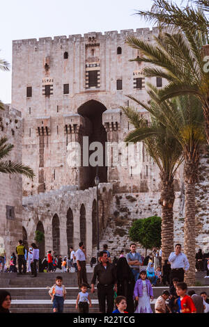 Le Gouvernorat d'Alep Alep, Syrie : les gens, passez devant la citadelle d'Alep, un grand château fort médiéval situé dans le centre de la vieille ville. Le site Banque D'Images