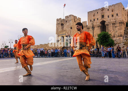 Le Gouvernorat d'Alep Alep, Syrie, : Les hommes en costumes traditionnels de la danse par la citadelle d'Alep. Banque D'Images