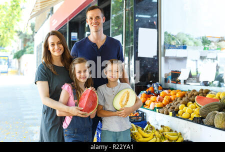 Famille avec enfants démonstration fruits frais en plein air magasin de fruits locaux Banque D'Images