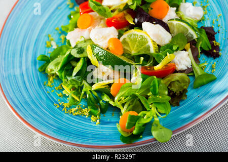 Une recette de salade avec de la morue marinés : hacher 200gr de filets de morue, faire mariner dans le jus de citron et poivre noir. Servir avec des feuilles de laitue, carottes fraîches un Banque D'Images