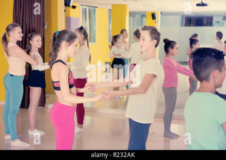 Groupe de pratique d'interpolations de mouvements vigoureux jive dans un studio de danse avec entraîneure Banque D'Images