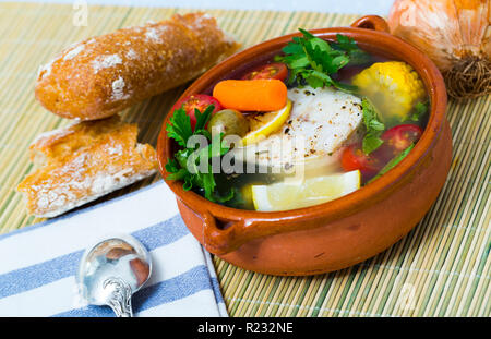 Recette potage pêcheur - bouillir merluccius tête pour bouillon. Ajouter 200 gr de steak de poisson, légumes (pommes de terre, carottes, maïs, l'échalote), sel, poivre. Faire cuire dans la vo Banque D'Images