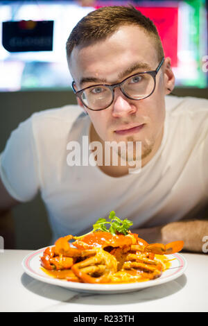 Les jeunes manger touristique style Singapour hot chili crab servi sur China Town. Plat de fruits de mer de l'Asie du sud-est. Banque D'Images