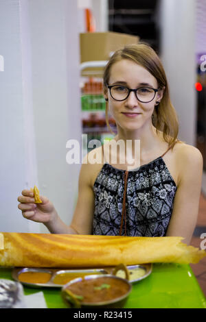 Les jeunes manger crêpe Dosa touristiques sur Little India à Singapour. Plat local en Asie du sud-est. Banque D'Images