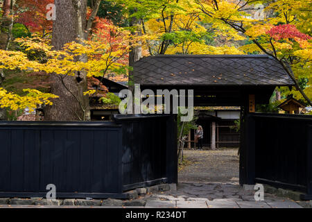 Porte de maison le long des samouraïs Bukeyashiki street à Kakunodate, du Japon à l'apogée de la couleur de l'automne. Banque D'Images