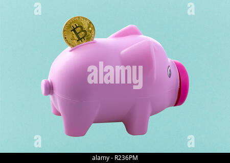 Pink piggy bank avec bitcoin sur fond azur Banque D'Images