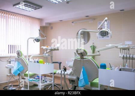 Clinique dentaire d'intérieur avec plusieurs dentistes président et d'outils. Clinique dentaire moderne bureau avec chaises vertes. Cabinet dentaire. Banque D'Images