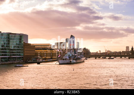 Vue sur le HMS Belfast musée par la Tamise au coucher du soleil la lumière. Banque D'Images