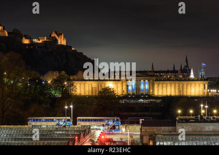 Edinburgh, Scotland, UK - 2 novembre 2018 : la galerie nationale d'Écosse et le château d'Édimbourg sont éclairées la nuit au-dessus de la verrière du Ra Waverley Banque D'Images