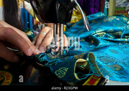 Inde, Himachal Pradesh, Manali, Gandhan Thekchokling Gompa : une femme coud une robe bleue avec une machine à coudre dans le tailleur du Bud Banque D'Images