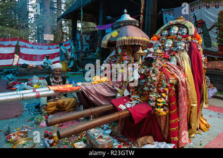 L'Inde, l'Himachal Pradesh, Manali, 08/08/2010 : un prêtre hindou se trouve près les masques et l'effigie de la déesse à l'Hadimba temple Hadimba à Manali Banque D'Images