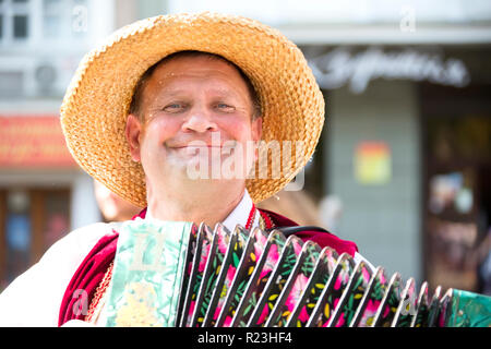.Un homme dans un chapeau de paille en jouant de l'harmonica.Harmonist Banque D'Images
