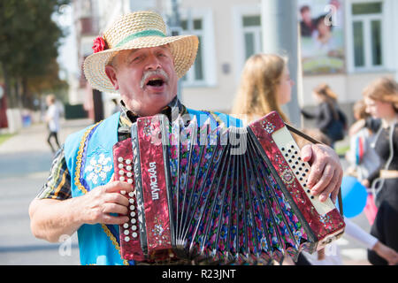 Le Bélarus, la ville de Gomel, le 15 septembre 2018. Maison de ville 24. Central Park.Un homme dans un chapeau de paille en jouant de l'harmonica.Harmonist Banque D'Images