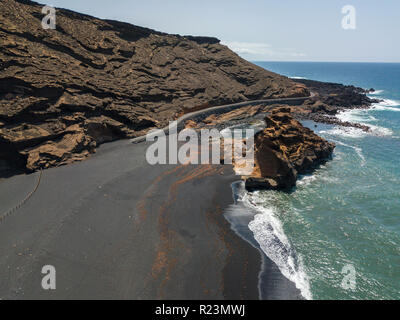 Vue aérienne de vagues se brisant sur une formation rocheuse. Playa El Golfo. Plage de sable noir de l'Charco de los Clicos. Lanzarote, îles Canaries, Espagne Banque D'Images