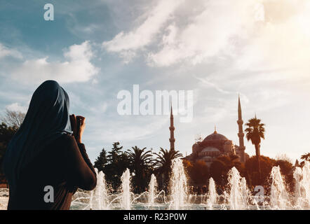 Jeune femme musulmane photographier mosquée bleue avec fontaine à l'avant-plan - Istanbul Banque D'Images