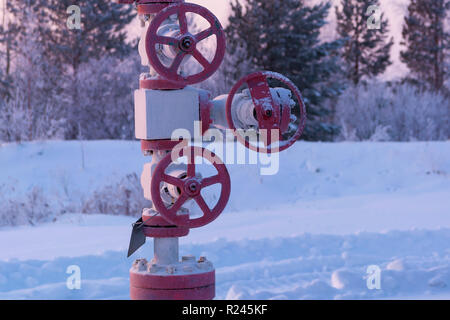 Distributeur de gaz naturel ou de pétrole couvert de neige. Jack la pompe à huile dans le travail. Loquet situé sur un puits de pétrole Banque D'Images