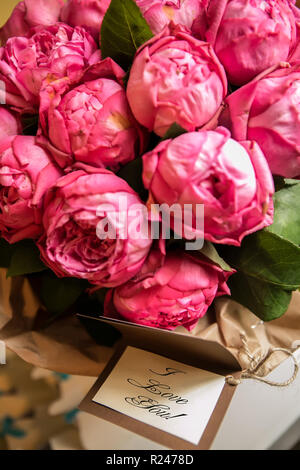 Bouquet de roses pivoine avec lettre et note disant - je t'aime Banque D'Images