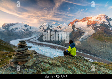 Randonneur assis sur des rochers en direction du glacier du Mont Rose, Zermatt, Valais, Alpes Suisses, Suisse, Europe Banque D'Images