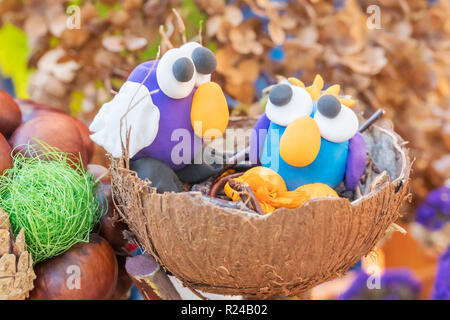 Les enfants de l'artisanat - deux oiseaux en pâte à modeler dans un nid de coque de noix de coco Banque D'Images