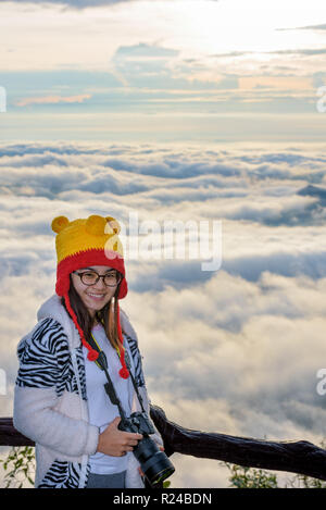 Femme touristes détenteurs d'un appareil photo DSLR sur belle nature paysage de brouillard est comme la mer en hiver au lever du soleil, à l'arrière-plan de vue haut Phu Banque D'Images