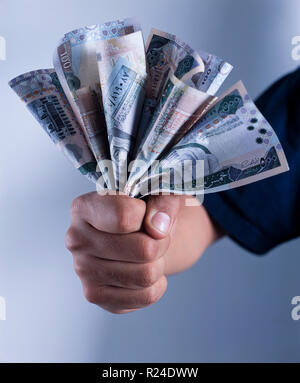 Hot Hand holding a bunch of Saudi Riyal billets de 500, 200 et 100 projets Banque D'Images