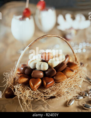 Panier avec des chocolats en forme de cœur avec deux verres de coktail still life composition Banque D'Images