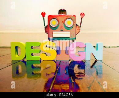 La tête du robot rétro rouge sur le mot DESIGN sur vieux plancher en bois avec des couleurs solarisées réflexion Banque D'Images