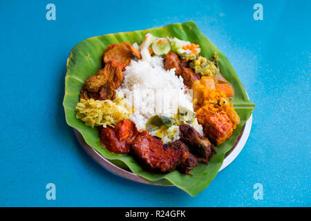 Sélection de produits frais préparés végétariens indiens les locaux de Malaisie servi sur des feuilles de banane en restaurant à Kuala Lumpur. Une cuisine traditionnelle en Asie Banque D'Images